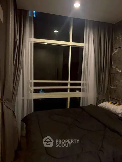 Cozy bedroom with large window and elegant curtains, perfect for restful nights.