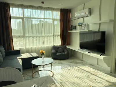 Spacious living room with modern decor, large windows, and natural light.