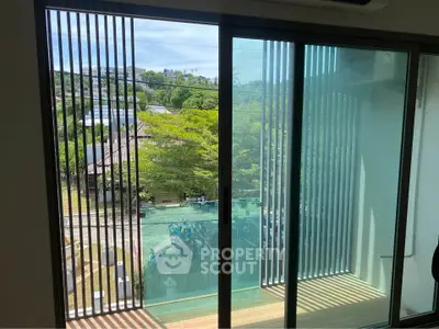Modern apartment with large glass doors opening to a scenic balcony view.