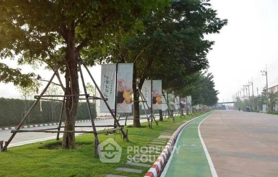 Scenic tree-lined street with banners in a residential area, perfect for peaceful living.