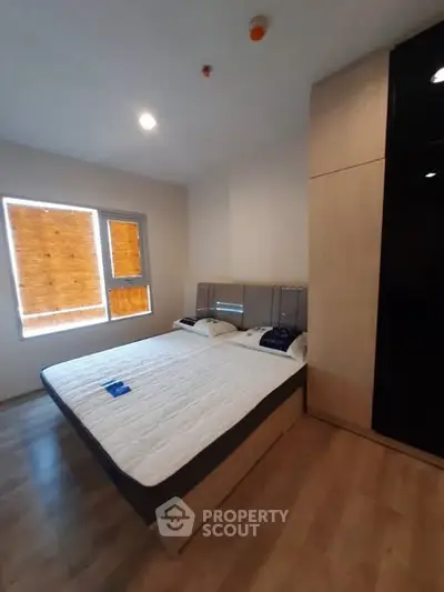 Modern bedroom with wooden flooring and large bed in a stylish apartment.