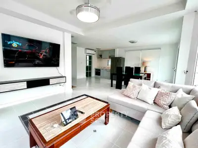 Spacious modern living room with sleek furniture and open kitchen layout, perfect for entertaining.