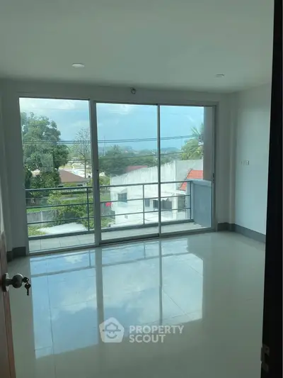 Spacious room with large windows offering a stunning view of the cityscape and greenery.