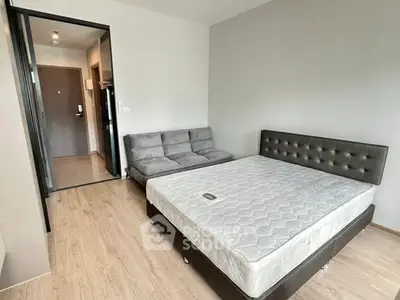 Modern bedroom with sleek furniture and wooden flooring in a stylish apartment.