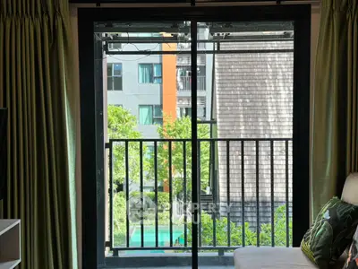 Charming apartment balcony with lush garden view and modern sliding doors.
