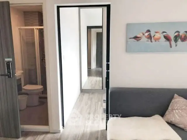 Modern apartment interior with cozy living room and bathroom view.