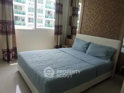 Modern bedroom with stylish decor and large window offering natural light.