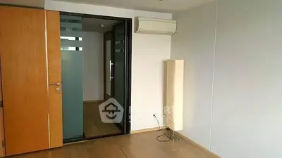 Spacious modern room with wooden flooring and glass door