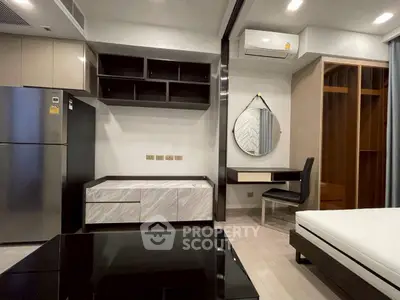 Modern studio apartment with sleek furniture and built-in storage solutions.
