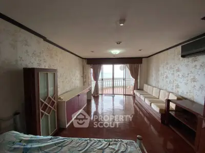 Spacious living room with balcony and ocean view, featuring elegant decor and ample natural light.