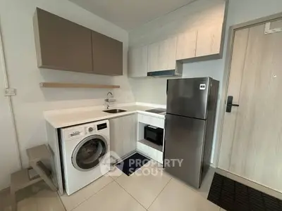 Modern compact kitchen with washing machine and stainless steel fridge