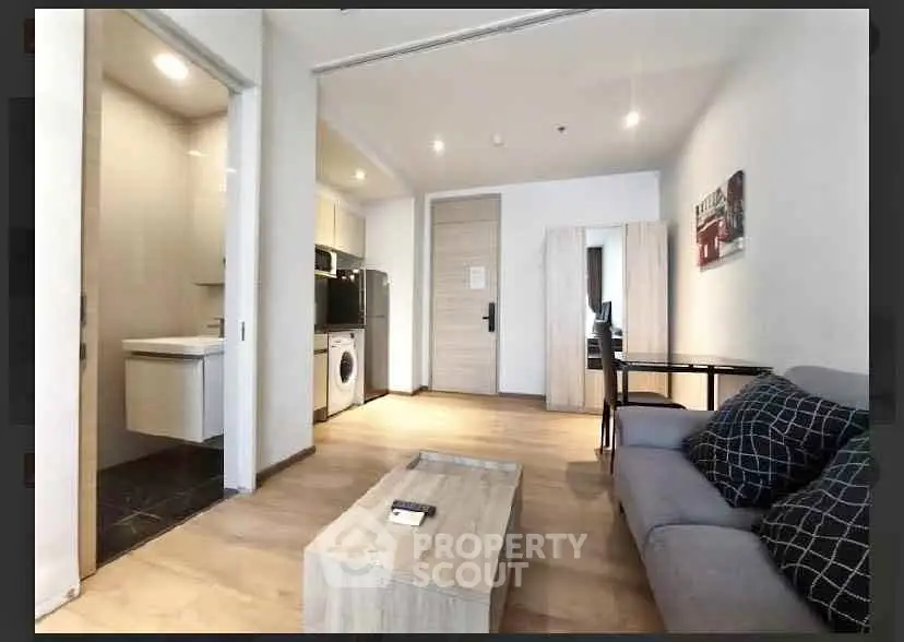 Modern living room with open kitchen and stylish decor in a contemporary apartment.