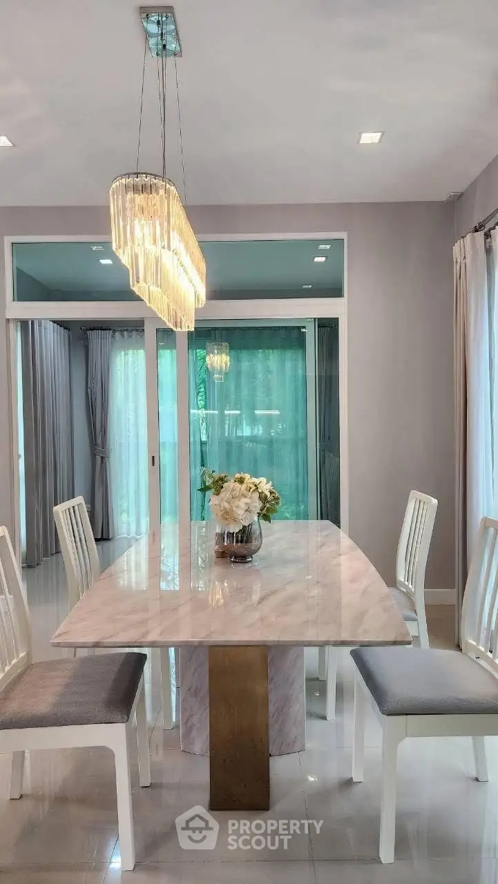 Elegant dining room with marble table and modern chandelier, perfect for stylish gatherings.