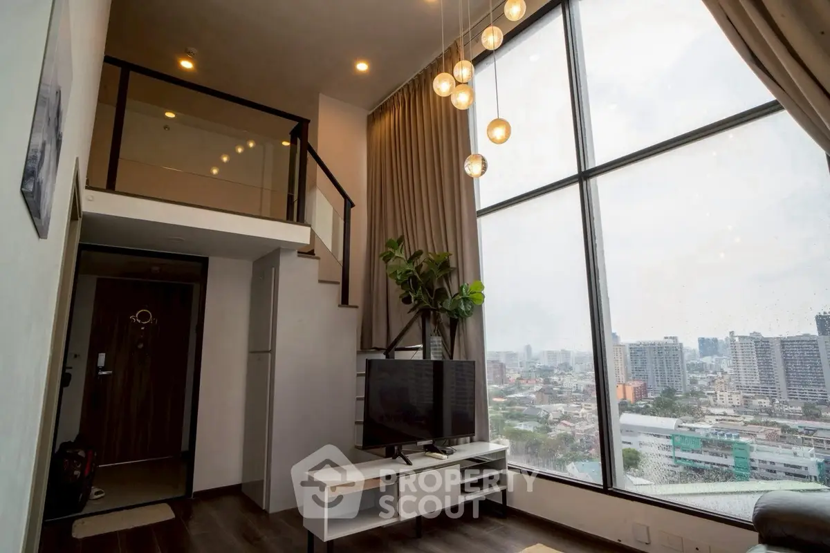 Stunning loft apartment with floor-to-ceiling windows and city view, featuring modern decor and high ceilings.