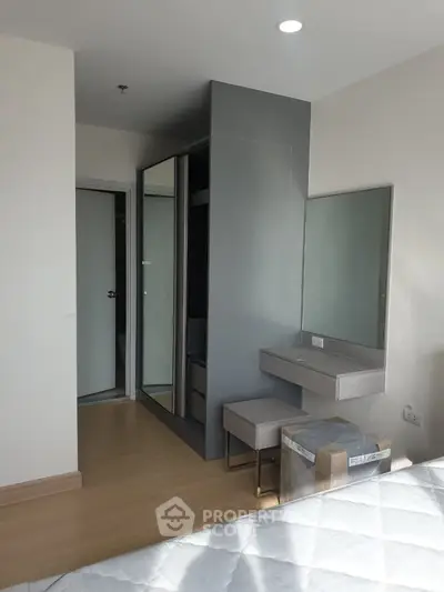 Modern bedroom with sleek wardrobe and vanity set, featuring natural light and minimalist design.