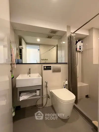 Modern bathroom with sleek fixtures and walk-in shower in contemporary apartment.