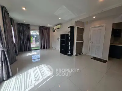 Spacious living room with large windows and modern shelving in a bright, airy home.