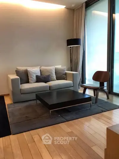 Modern living room with sleek furniture and large windows for natural light.