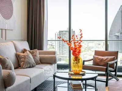 Stylish living room with modern decor and city view, featuring a cozy sofa and elegant armchair.