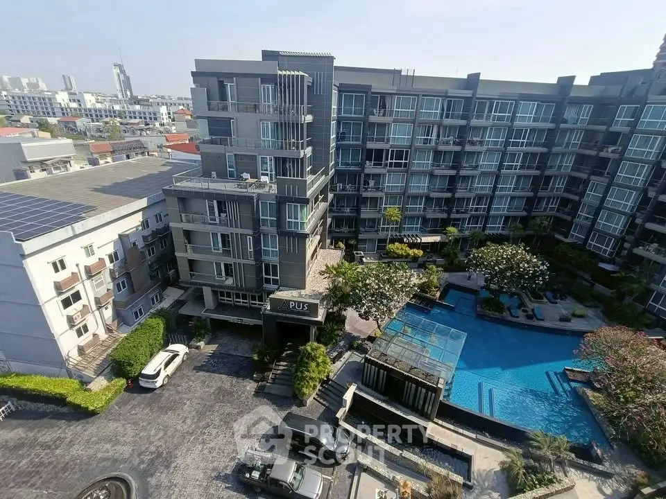 Modern condominium complex with pool and lush landscaping in urban setting
