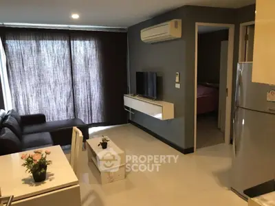 Modern living room with sleek furniture and open layout, featuring a cozy dining area and stylish decor.