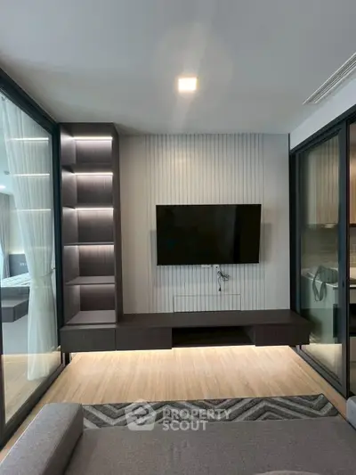 Modern living room with sleek TV setup and glass partitions