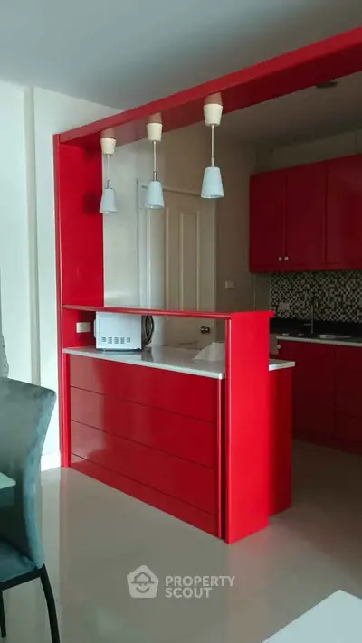 Modern kitchen with vibrant red cabinetry and sleek design