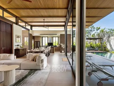 Luxurious open-plan living room with pool view, high ceilings, and elegant decor in a modern home.