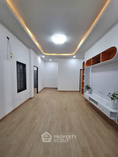 Spacious modern living room with elegant ceiling lights and wooden flooring