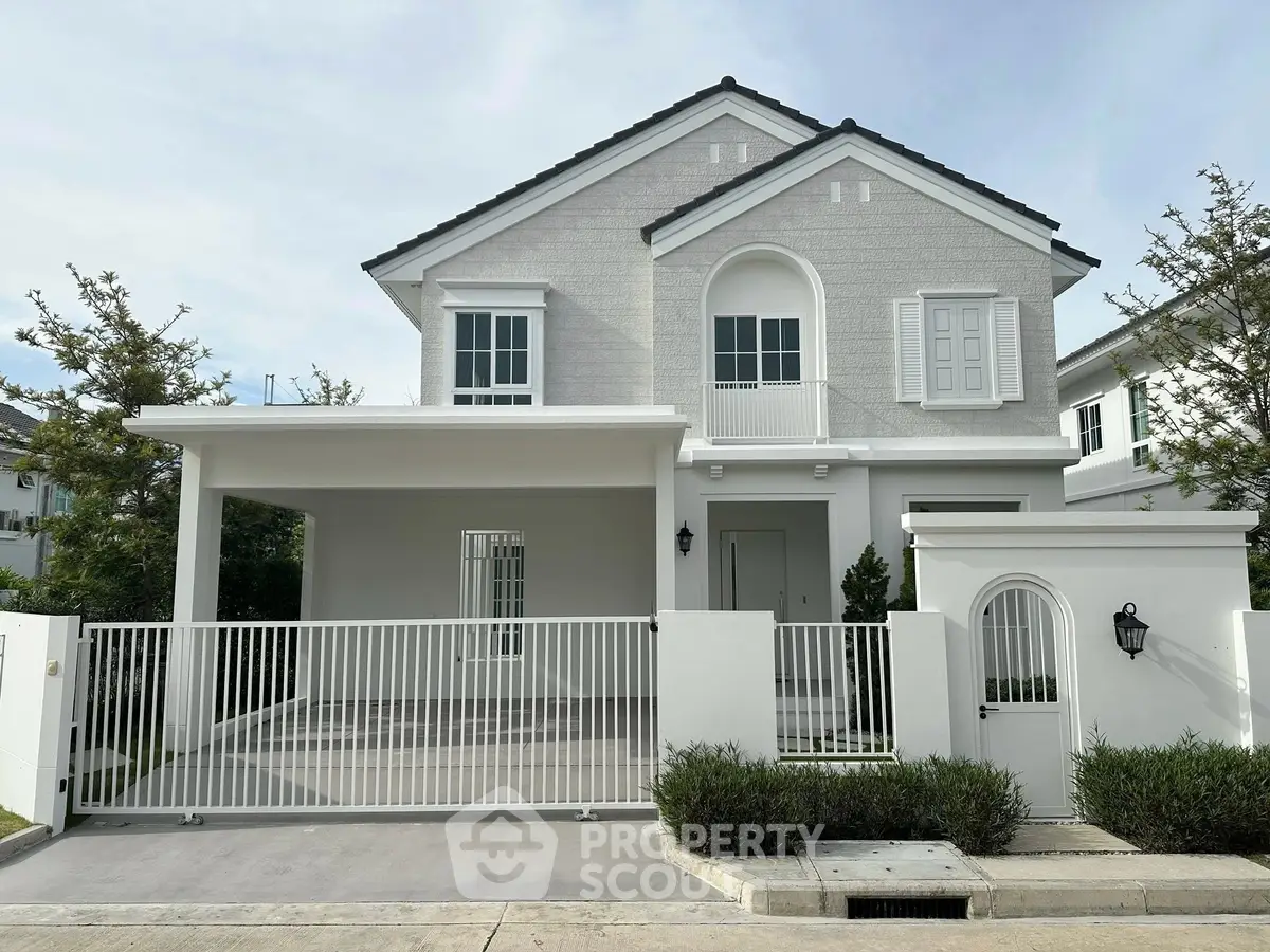 Charming two-story house with modern facade and gated driveway in a serene neighborhood.
