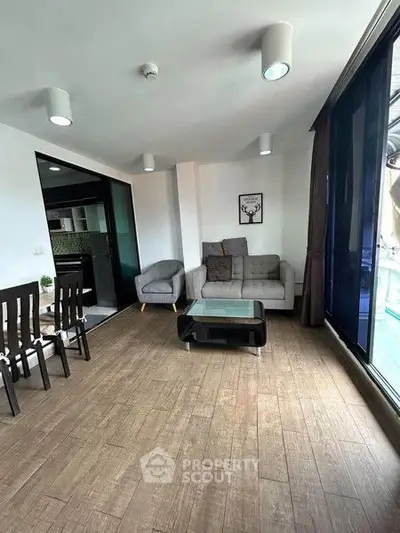 Modern living room with stylish decor and large windows offering natural light.