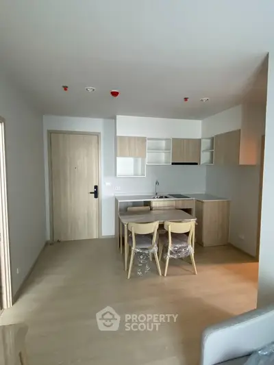 Modern open-layout kitchen with sleek cabinetry and dining area in a stylish apartment.