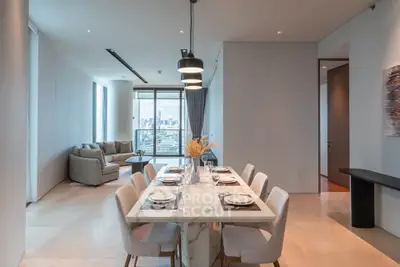 Luxurious open-plan dining and living area with city view, elegant furnishings, and modern lighting.