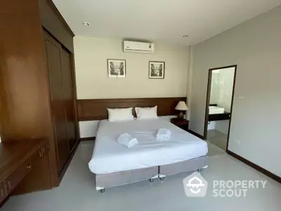 Spacious bedroom with modern decor and ensuite bathroom in a stylish apartment.