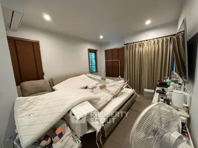 Cozy bedroom with modern decor and natural light, featuring a comfortable bed and stylish window treatments.