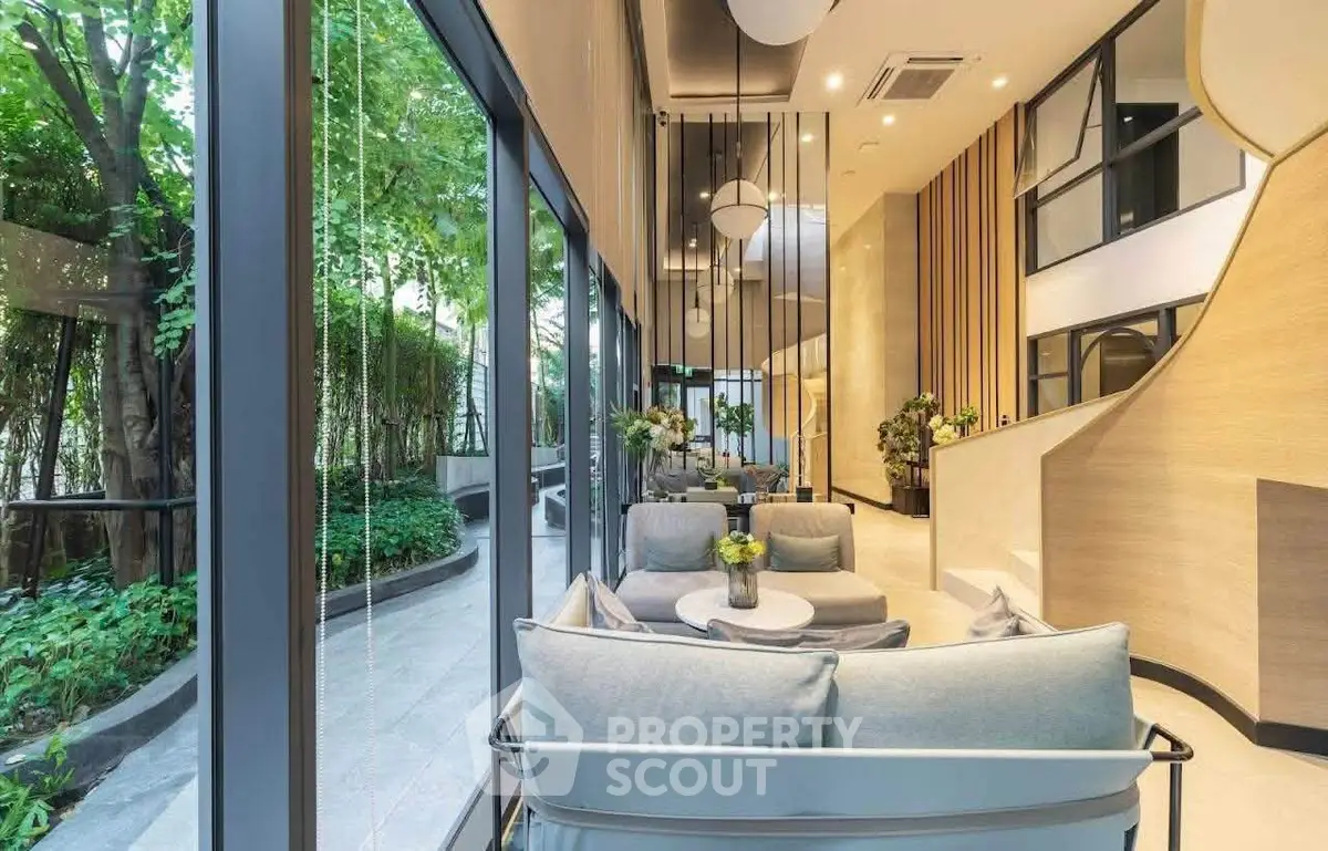 Luxurious modern living room with floor-to-ceiling windows and lush garden view, perfect for relaxation.
