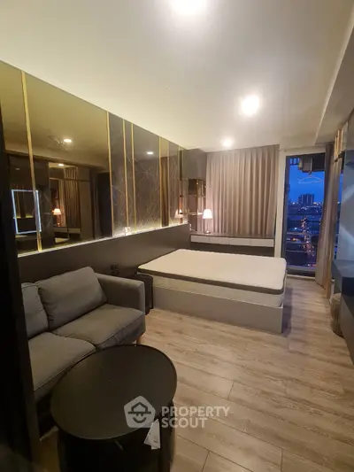 Luxurious modern bedroom with city view, featuring elegant decor and cozy seating area.