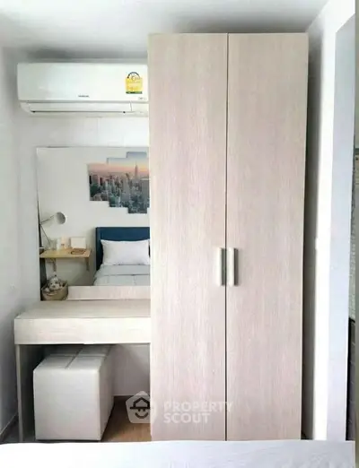 Cozy bedroom with modern wardrobe and air conditioning, perfect for comfortable living.