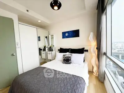 Modern bedroom with city view, featuring stylish decor and ample natural light.
