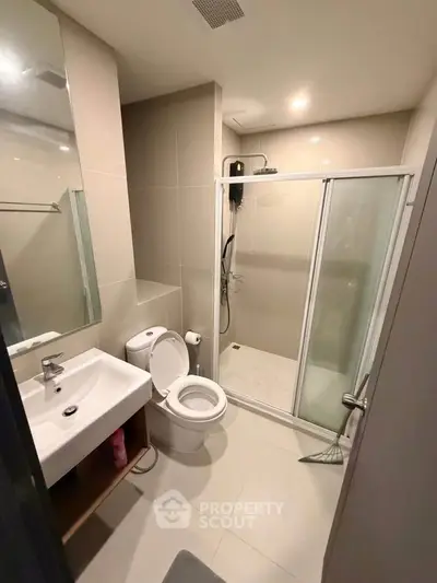 Modern bathroom with glass shower and sleek fixtures in a contemporary apartment.