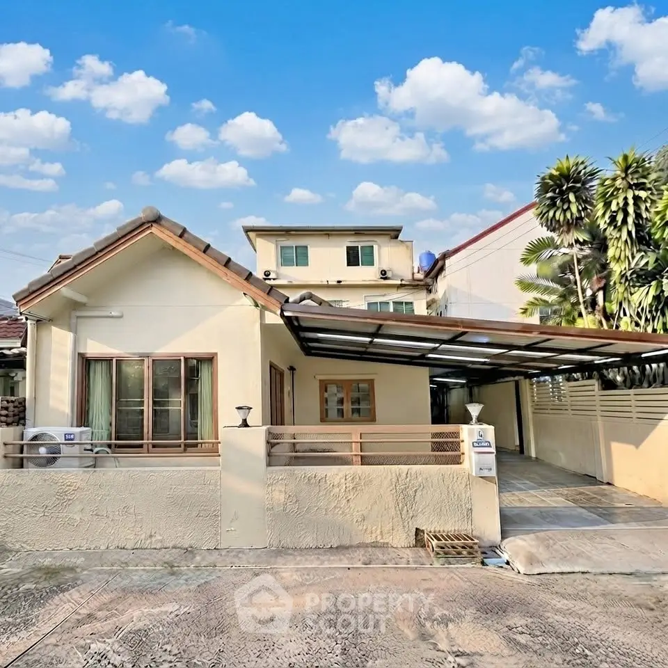 Charming single-story house with carport and lush greenery, perfect for family living.
