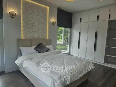 Elegant bedroom with modern design, large window, and built-in wardrobe