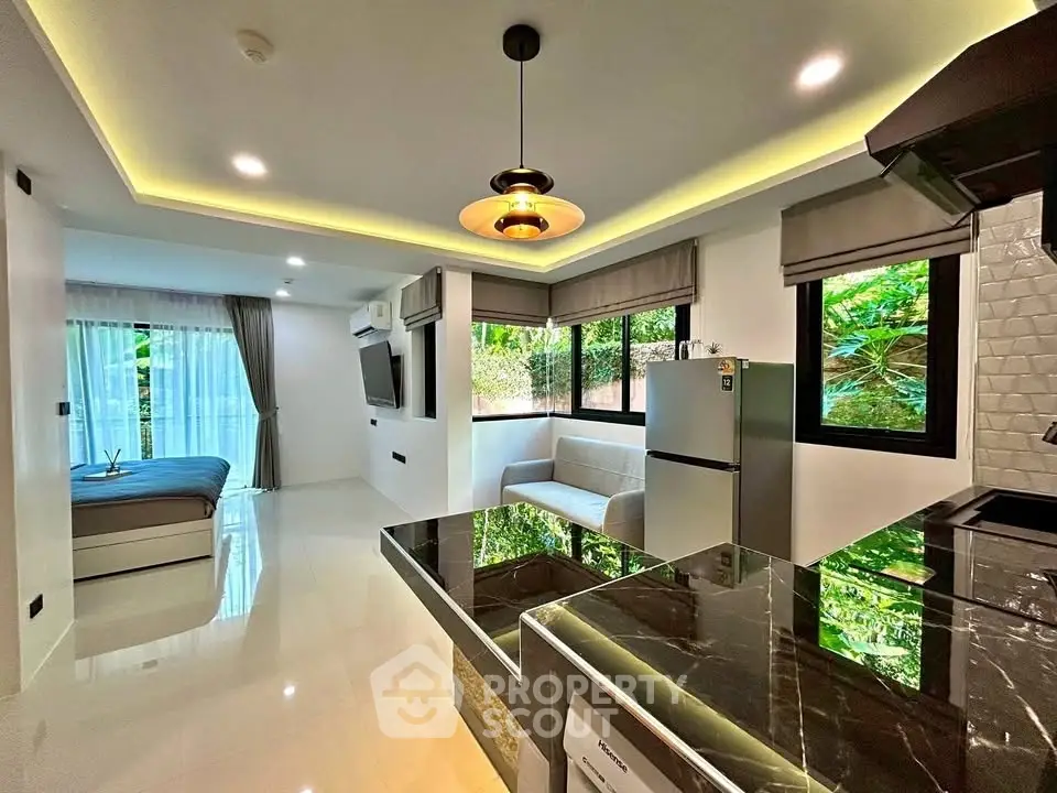 Modern open-plan living room with sleek kitchen and lush garden view.