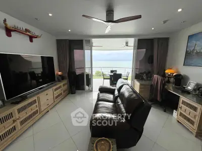 Luxurious living room with ocean view and modern furnishings, featuring a spacious balcony.