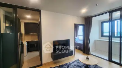 Modern apartment interior with open living room, kitchen, and bedroom view.