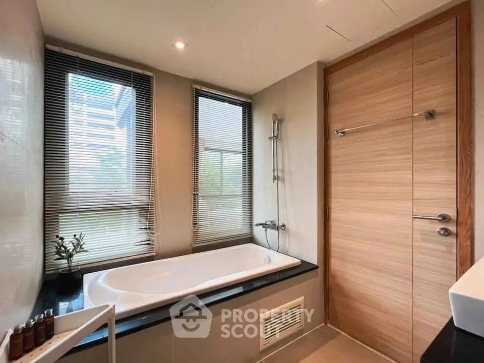 Modern bathroom with large windows and sleek bathtub in luxury apartment