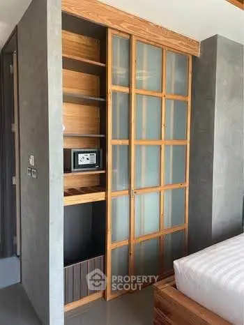 Modern bedroom with built-in wooden wardrobe and safe, featuring sleek design and cozy ambiance.