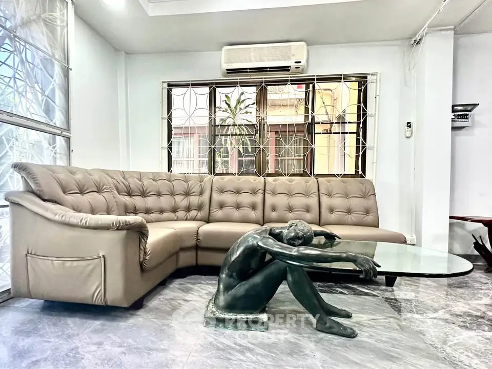 Spacious living room with unique sculpture coffee table and modern sectional sofa.