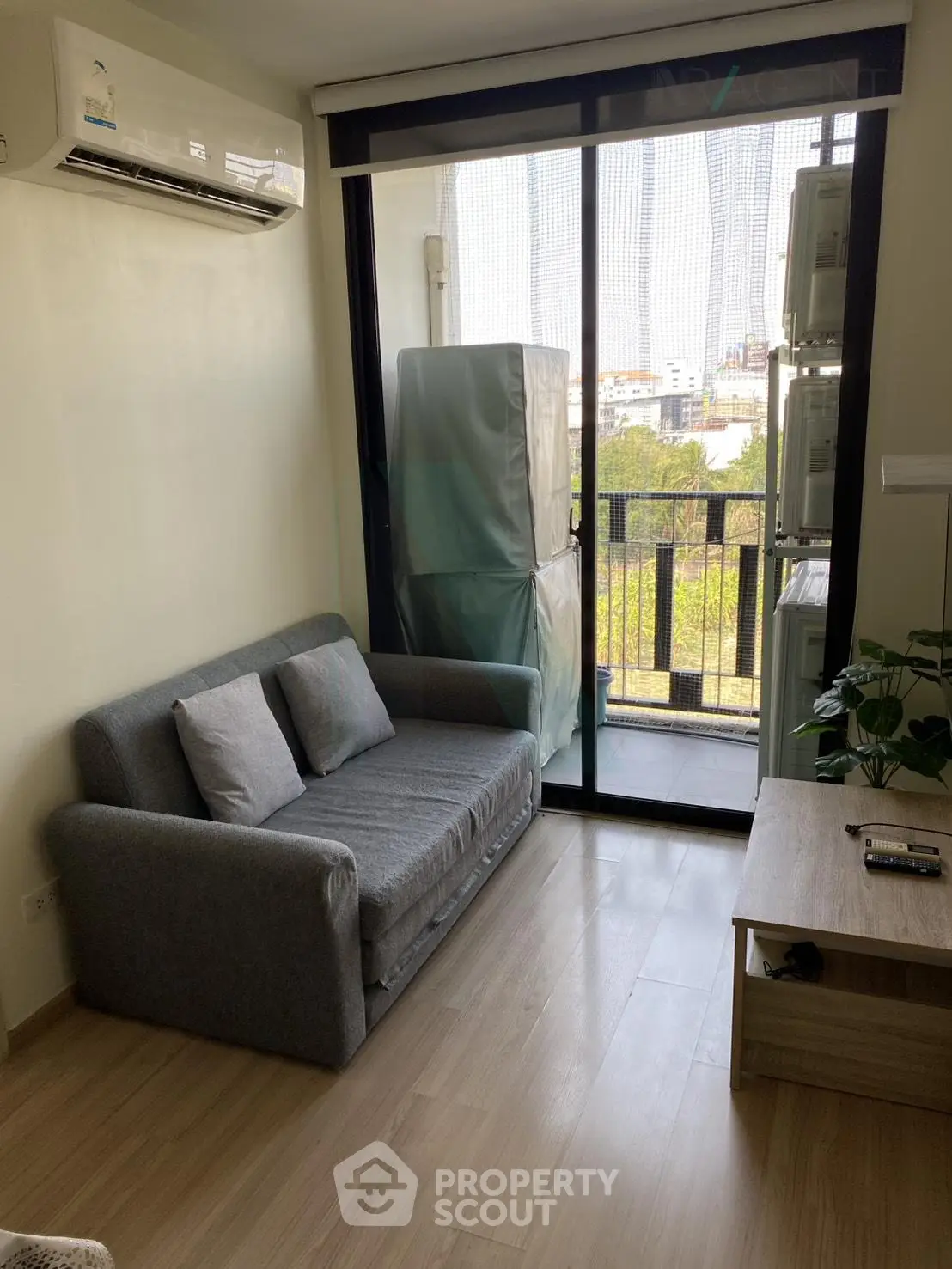 Cozy living room with modern sofa and balcony view in urban apartment