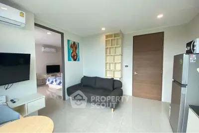 Modern living room with sleek furniture and open layout, featuring a cozy sofa and wall-mounted TV.